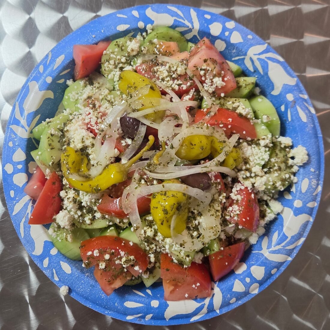 Classic Greek Salad — Ripe tomatoes, cucumber, onion, crumbled feta, kalamata olives, pepperoncini peppers, and our house made vinaigrette